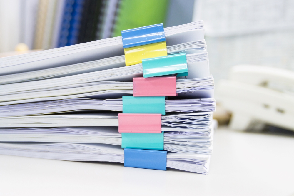 A close up of neat stacks of paper compiled nicely, representing a production printer.